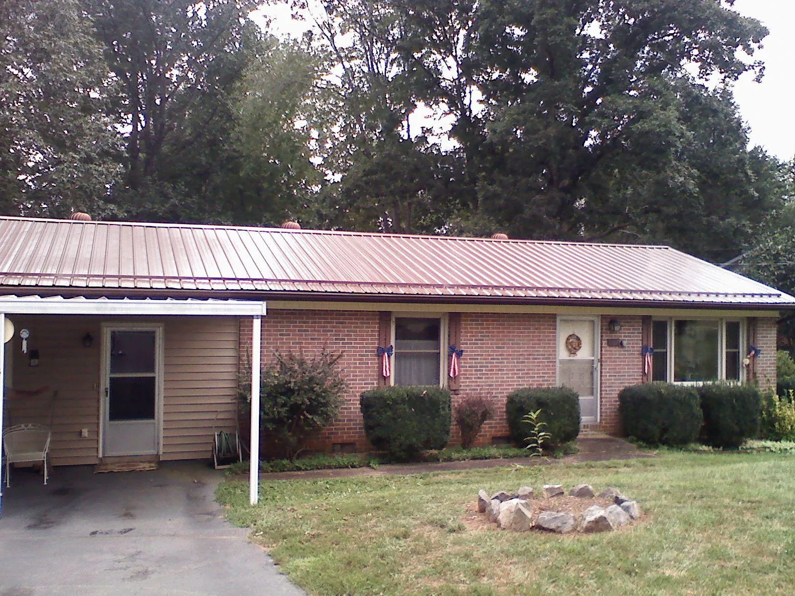 Bronze metal roof and carport on a brick ranch home — Roof Repair work by our crew in Temple